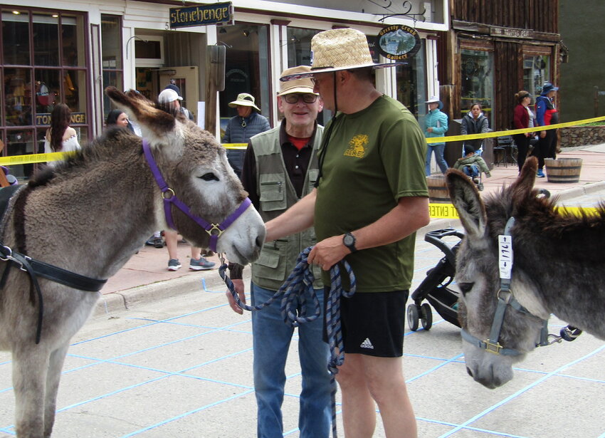 Rotary member Bob Loeffler talks with Dewane Mosher with burros Bunny, left, and Bluebell.
